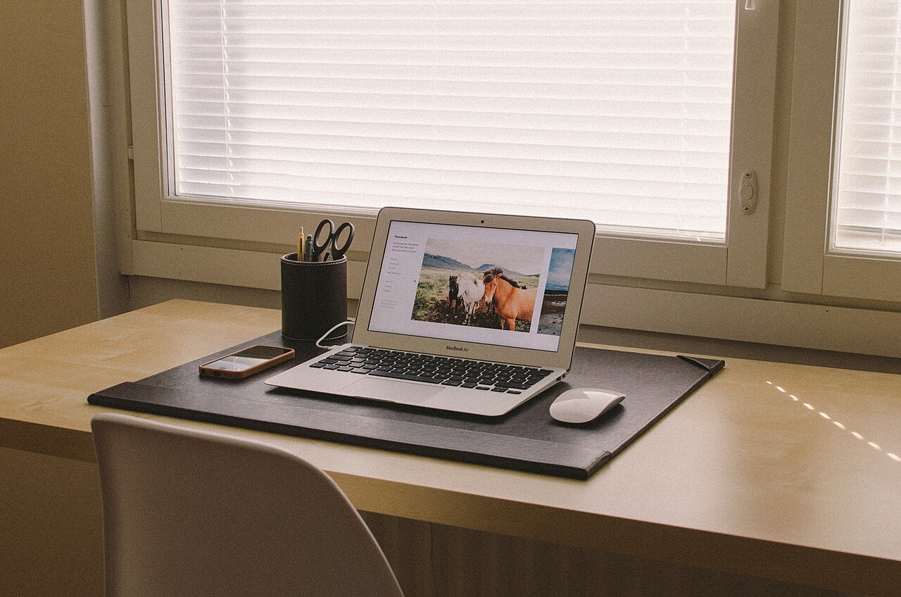 A smartphone and laptop on a desk